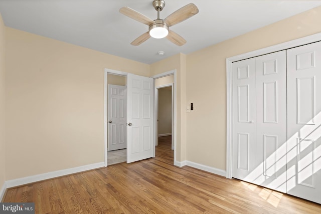 unfurnished bedroom with a closet, ceiling fan, light wood-style floors, and baseboards