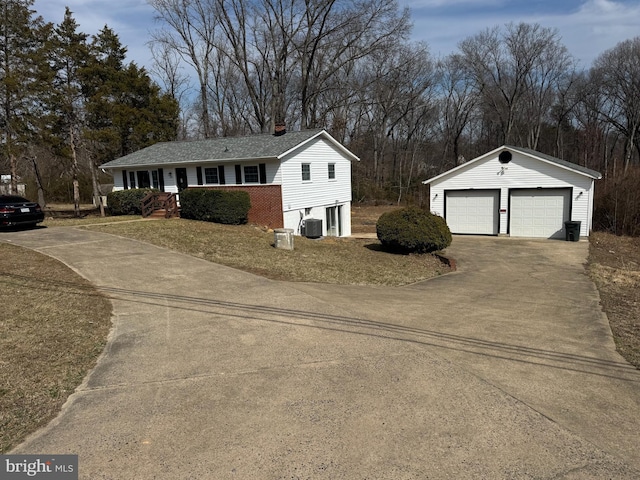 view of front of house featuring an outbuilding, central air condition unit, a chimney, and a garage