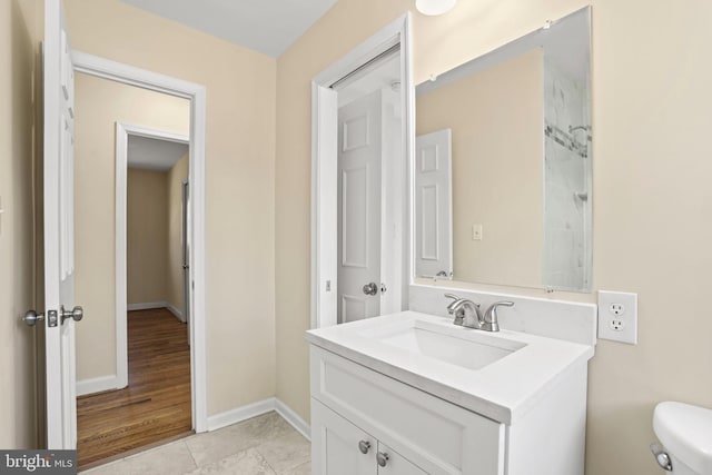 bathroom featuring tile patterned floors, baseboards, toilet, and vanity