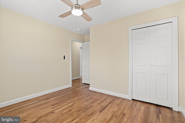 unfurnished bedroom featuring a closet, baseboards, wood finished floors, and a ceiling fan