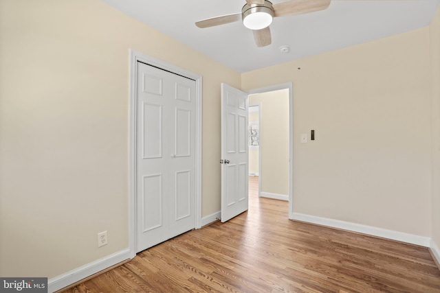 unfurnished bedroom with ceiling fan, light wood-type flooring, and baseboards