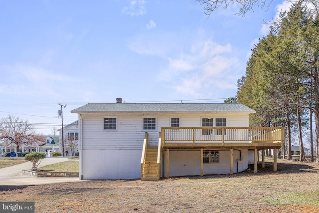 rear view of house with stairway and a wooden deck