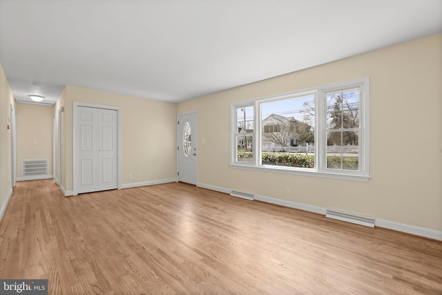 unfurnished living room featuring visible vents, baseboards, and light wood finished floors