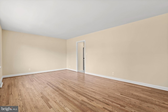 unfurnished room with wood finished floors and baseboards