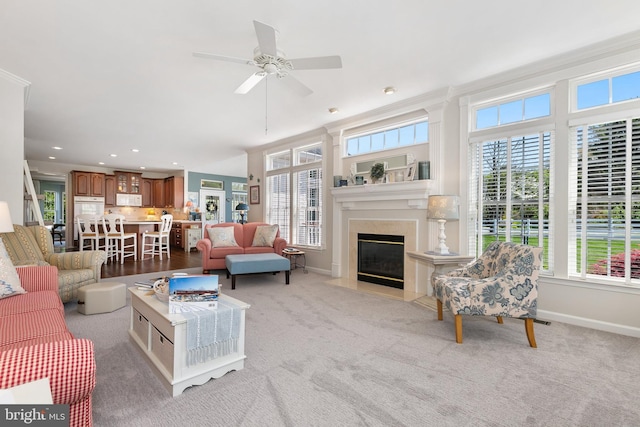 living area with recessed lighting, light carpet, ceiling fan, a fireplace, and baseboards