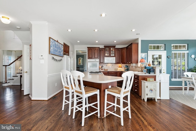dining room with recessed lighting, dark wood finished floors, stairs, and baseboards