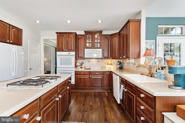 kitchen featuring recessed lighting, a sink, white appliances, dark wood-type flooring, and light countertops
