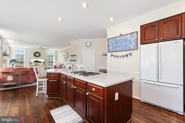 kitchen featuring dark wood finished floors, white appliances, light countertops, ceiling fan, and open floor plan