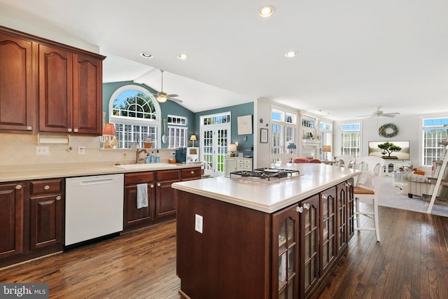 kitchen with a sink, ceiling fan, light countertops, white dishwasher, and open floor plan