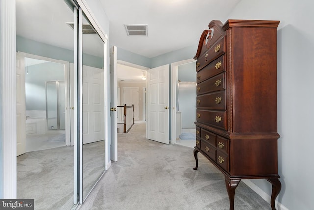 hallway with visible vents and light colored carpet