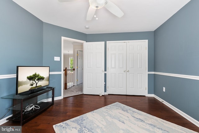 bedroom with wood finished floors, a closet, a ceiling fan, and baseboards