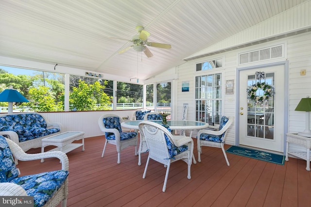 sunroom featuring a healthy amount of sunlight, outdoor dining space, and a ceiling fan