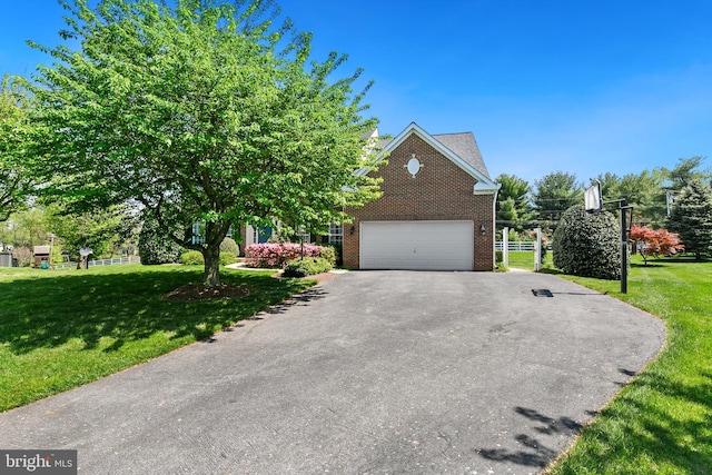view of property hidden behind natural elements with brick siding, an attached garage, aphalt driveway, and a front lawn