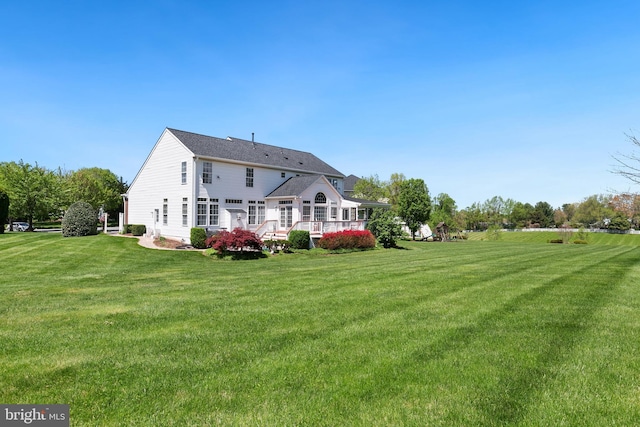 rear view of house with a lawn and a deck