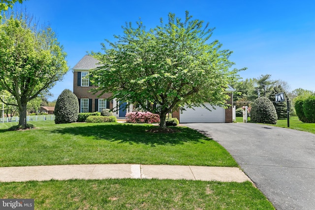 view of front of home with a garage, brick siding, aphalt driveway, and a front lawn