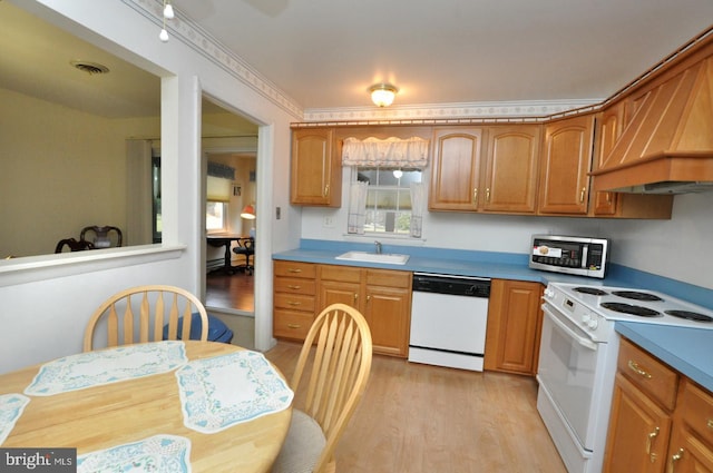 kitchen featuring white appliances, visible vents, premium range hood, light wood-style flooring, and a sink