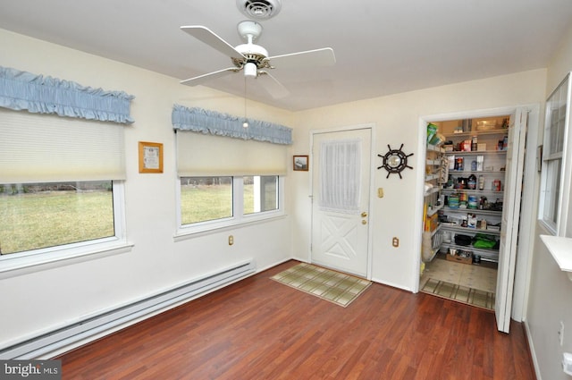 foyer entrance featuring visible vents, baseboard heating, wood finished floors, and a ceiling fan