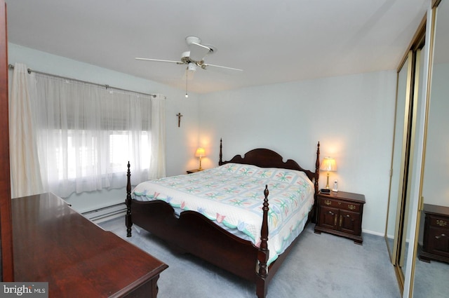 bedroom with a closet, light carpet, baseboard heating, and ceiling fan