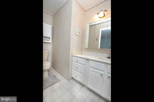 bathroom featuring tile patterned flooring, toilet, vanity, and baseboards