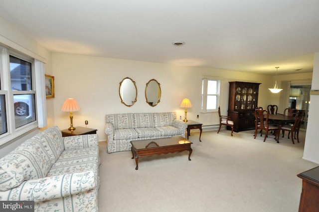 carpeted living room featuring visible vents and baseboard heating