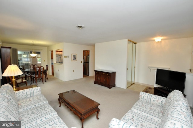 living area with visible vents and carpet floors