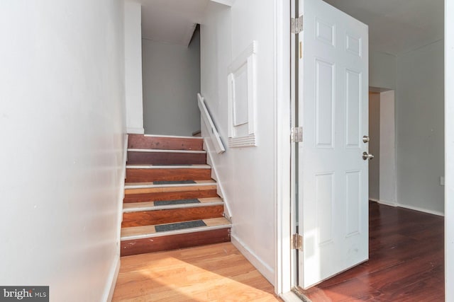 stairs with wood finished floors and baseboards