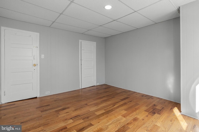 spare room featuring a paneled ceiling and light wood-style floors