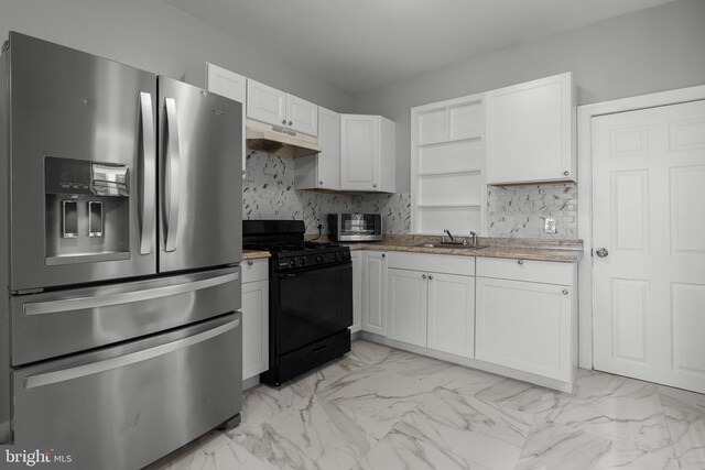 kitchen featuring marble finish floor, stainless steel refrigerator with ice dispenser, white cabinets, black range with gas cooktop, and under cabinet range hood