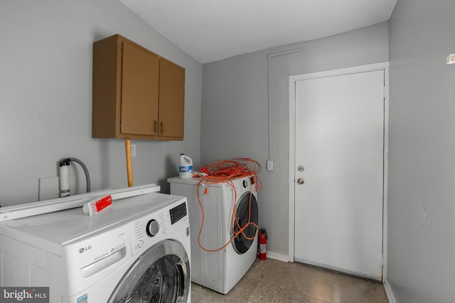 laundry room with cabinet space, baseboards, and separate washer and dryer