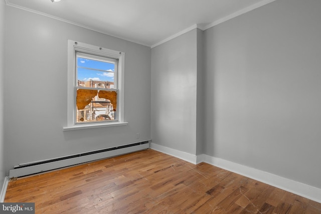 unfurnished room featuring baseboards, baseboard heating, wood finished floors, and crown molding