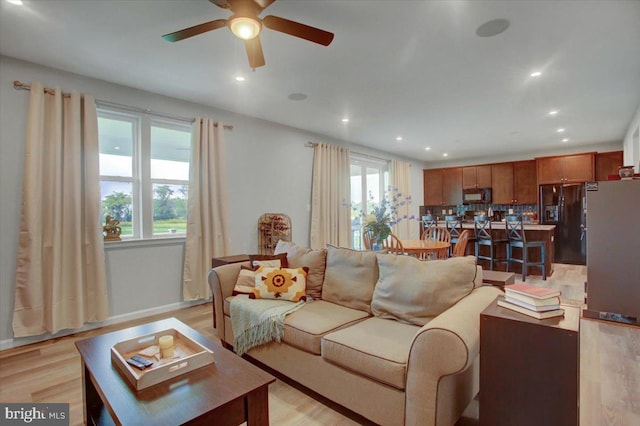 living area featuring ceiling fan, light wood finished floors, and recessed lighting