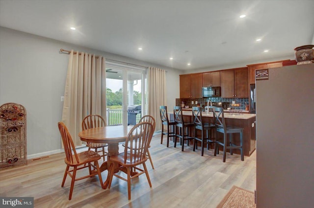 dining space with light wood-style flooring, baseboards, and recessed lighting