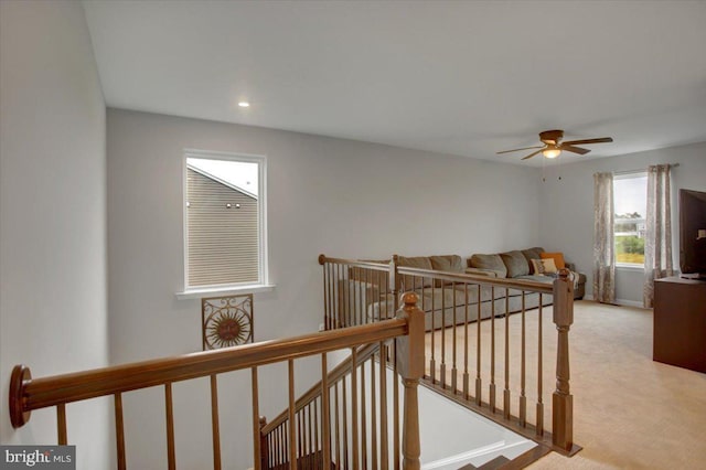 corridor featuring carpet flooring and an upstairs landing