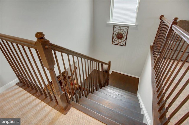 staircase with baseboards and wood finished floors