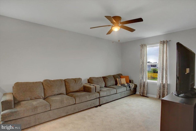 carpeted living area with a ceiling fan