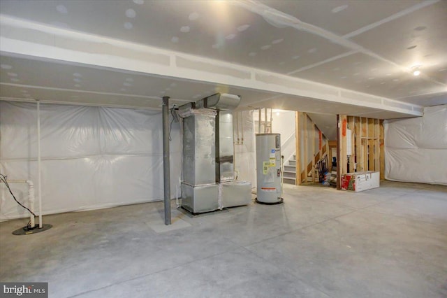 unfinished basement featuring gas water heater, stairway, and heating unit