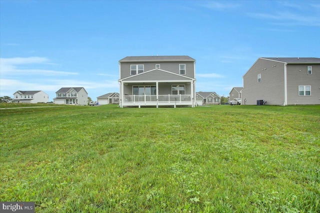 rear view of house featuring a porch and a yard