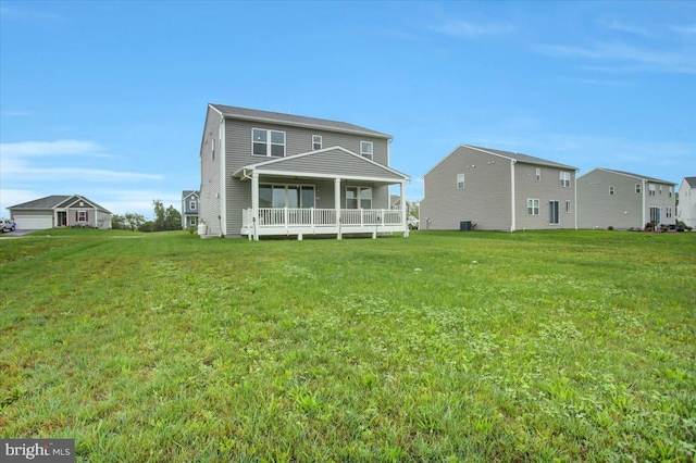 rear view of property featuring a porch and a yard