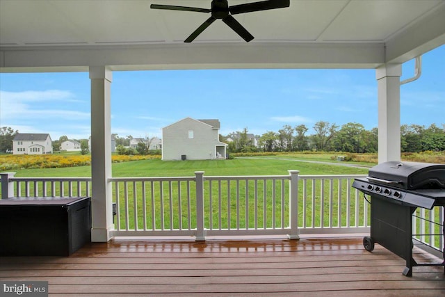 deck with a lawn, area for grilling, and ceiling fan