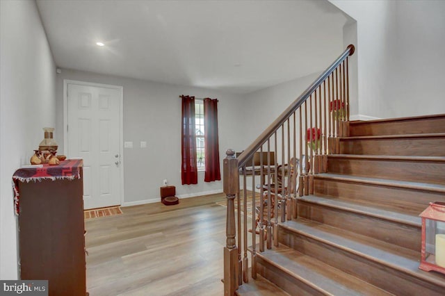 staircase featuring wood finished floors and baseboards