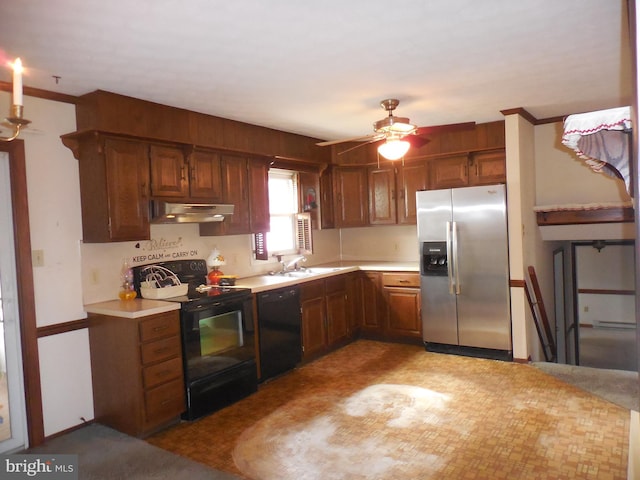 kitchen with light countertops, brown cabinetry, ceiling fan, under cabinet range hood, and black appliances