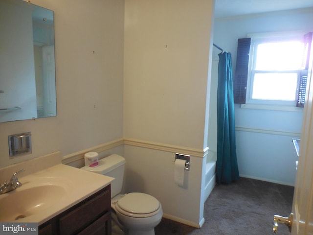 bathroom featuring toilet, shower / tub combo, vanity, and baseboards