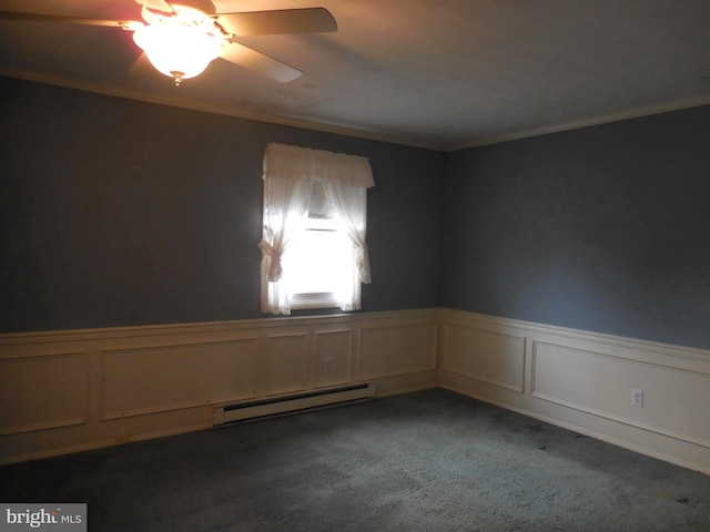 empty room with carpet floors, a wainscoted wall, crown molding, and baseboard heating