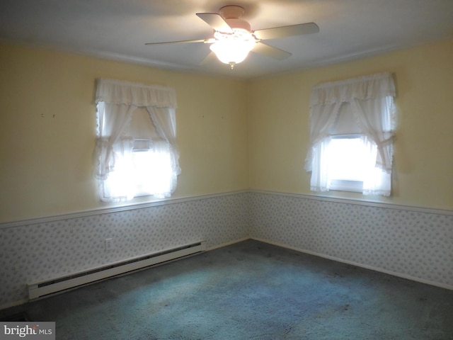 spare room with carpet, a wainscoted wall, a baseboard heating unit, ceiling fan, and wallpapered walls