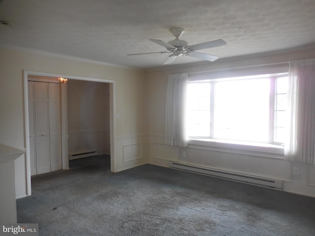 spare room with a baseboard heating unit, a baseboard radiator, crown molding, and carpet