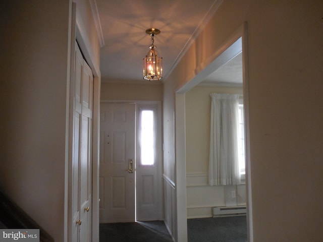 entrance foyer featuring a notable chandelier, a baseboard heating unit, and crown molding