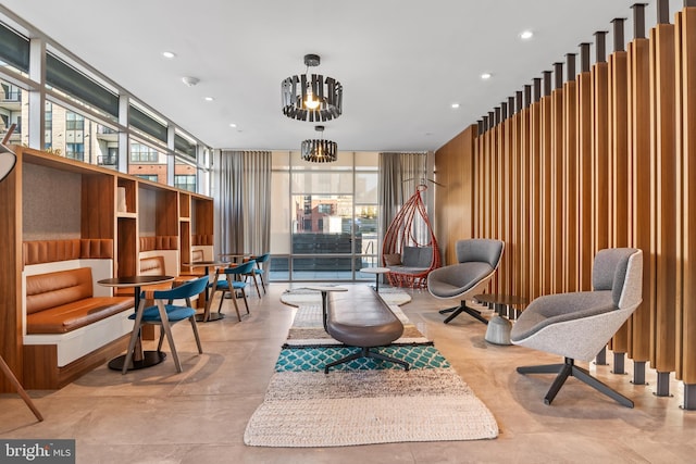 sitting room with recessed lighting, an inviting chandelier, and a wall of windows