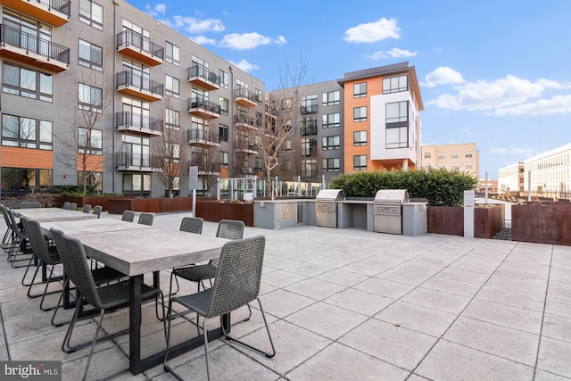 view of patio featuring outdoor dining area, area for grilling, and an outdoor kitchen