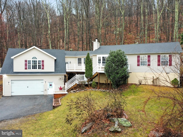 view of front of property featuring stairs, aphalt driveway, a front lawn, and a garage