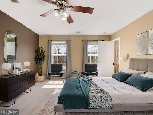 bedroom featuring visible vents, light carpet, and ceiling fan